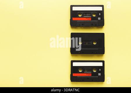 Collection of Cassette Tapes Arranged on a Yellow Background in a Simple Set Stock Photo