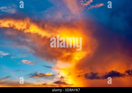 Dramatic afterglow of the sun in the evening sky with orange wispy clouds Stock Photo