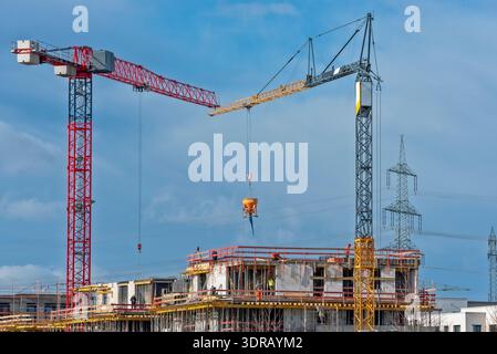 Two construction cranes on the building site of a house Stock Photo