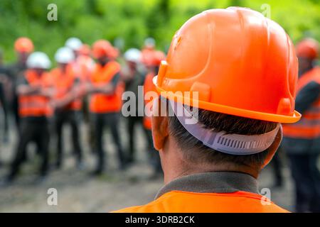 Building concept. Architector, engineers on constructing site. Helmet builder. Many construction workers helmet. Engineer team in hardhat for work Stock Photo