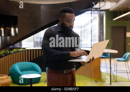 Using laptop, businessman working in modern office environment, focusing on tasks Stock Photo