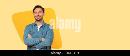 Smiling Man Stands With Arms Crossed in a Bright Yellow Background Setting During the Day Stock Photo