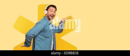 Man Wearing Headphones Smiles While Posing Against a Yellow Background Stock Photo