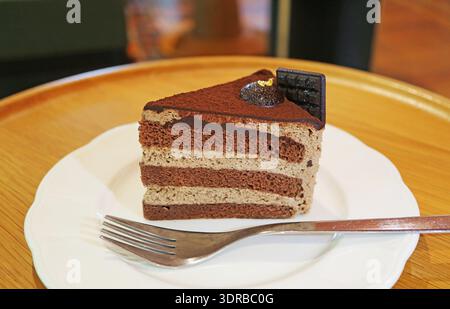 A Slice of Delectable Rich Chocolate Chiffon Cake Served on Wooden Table Stock Photo