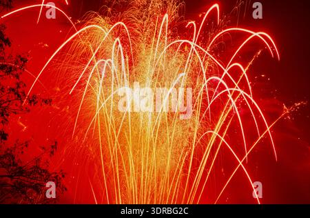The colourful exploding rockets, firecrackers and comets of a firework display in the night sky Stock Photo