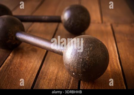 Old rusty dumbbells on wood background texture Stock Photo