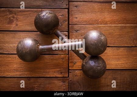 Old rusty dumbbells on wood background texture Stock Photo