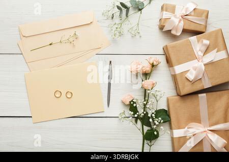 Collection of Gifts and Wedding Items on a Wooden Table With Flowers and Stationery Stock Photo