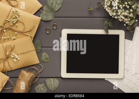 Collage of Wedding Planning Items on a Table With Gifts, a Tablet, and Flowers Stock Photo