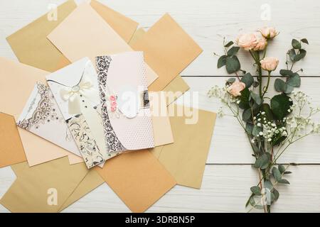 Collage of Envelopes With a Flower Arrangement on a Wooden Surface Stock Photo