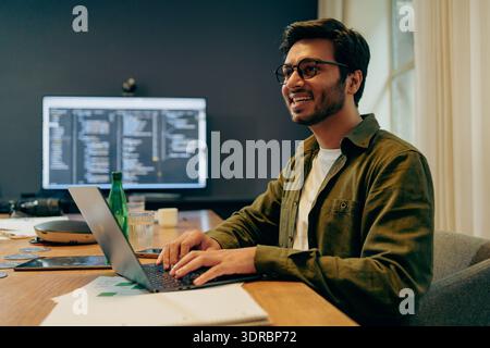 Casual Dressed Programmer Concentrating On Programming On Multiple Monitors In Bright Home Office Environment Stock Photo