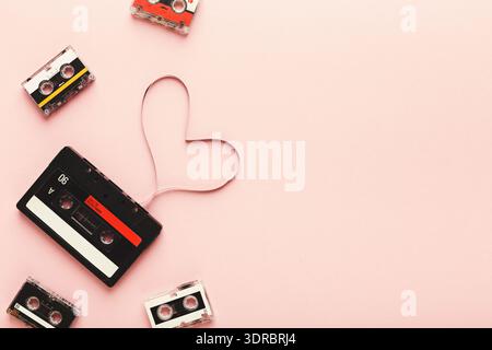 Collection of Cassette Tapes Arranged in a Heart Shape on a Pink Background Stock Photo