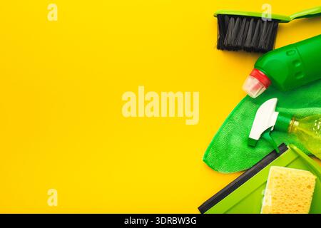 Cleaning Supplies and Tools Arranged on a Bright Yellow Background for Household Tasks and Chores Stock Photo
