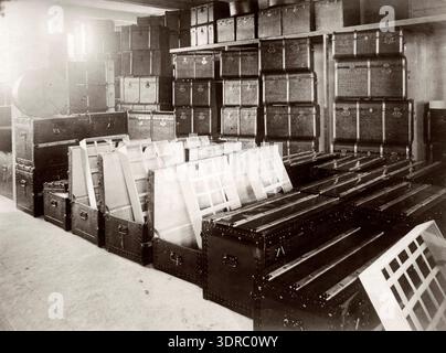 Koffers, kofferfabrieken by P. van Tol before 1917 shows the warehouse of the Zuid-Hollandsche Kofferfabriek in The Hague. The image depicts suitcases stored and organized within the facility, documenting early 20th century luggage manufacturing, storage practices, warehouse management, and industrial organization. It provides factual visual evidence of Dutch production and logistical operations for suitcase manufacturing. Stock Photo