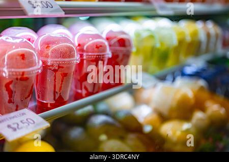 Plastic cups with fresh fruits displayed in a commercial refrigerator. Fruit salad Stock Photo