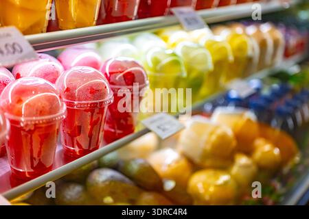 Plastic cups with fresh fruits displayed in a commercial refrigerator. Fruit salad Stock Photo