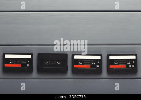 Collection of Vintage Audio Cassettes Displayed on a Wooden Surface in Various Positions Stock Photo