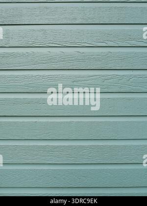 Horizontal wooden facade in light gray-green, visible grain, evenly spaced boards, matte and well-kept. Copyspace. Stock Photo