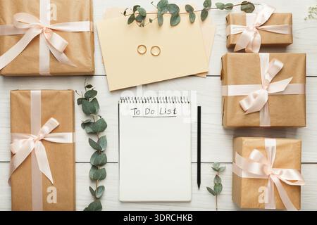 Collection of Gifts and a to Do List on a Wooden Surface With Rings and Envelopes Stock Photo