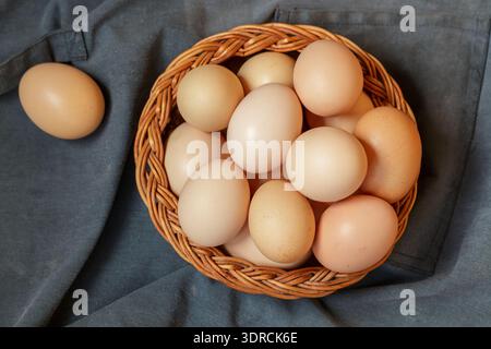 Organic raw brown chicken eggs in a wicker basket. Easter. Rustic style. Soft focus, copy space, top view Stock Photo
