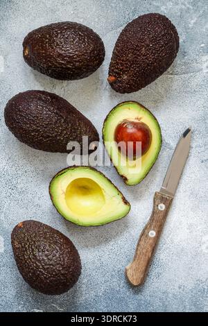 Whole and cut avocados on grey table, flat lay Stock Photo - Alamy