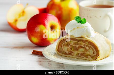 Strudel with Apple and cinnamon. Traditional layered homemade pie with fruit filling, served with powdered sugar and vanilla ice Stock Photo