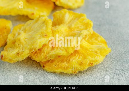 Dried yellow pineapple rings on a grey concrete or stone background. Useful Healthy snack. Selective focus, copy space Stock Photo