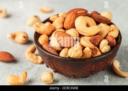 Healthy mix of different nuts in a bowl on a gray concrete or stone background. Almonds, hazelnuts, cashews. A Useful snack. Goo Stock Photo