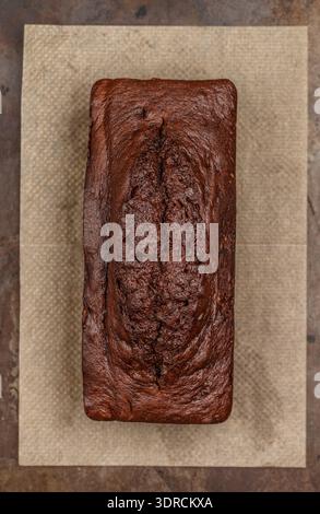 Homemade chocolate pound cake loaf on the baking sheet.  Delicious dessert.  Selective focus, top view Stock Photo