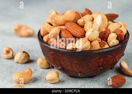 Healthy mix of different nuts in a bowl on a gray concrete or stone background. Almonds, hazelnuts, cashews. A Useful snack. Goo Stock Photo