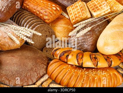 Freshly baked rye and wheat bread on the table. Whole and sliced loaves Stock Photo