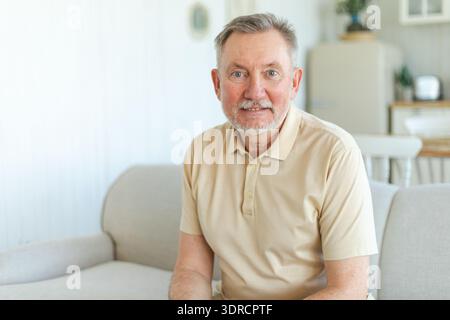 Confident stylish middle aged senior man at home. Older mature 70s man smiling. Happy attractive senior beard grandfather lookin Stock Photo