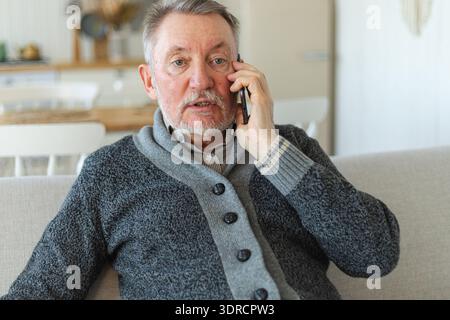 Happy middle aged senior man talking on smartphone with family friends. Older mature grandfather with cell phone talking with gr Stock Photo