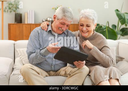 Video call. Happy senior couple woman man with tablet having video call. Mature old grandmother grandfather talking speaking onl Stock Photo