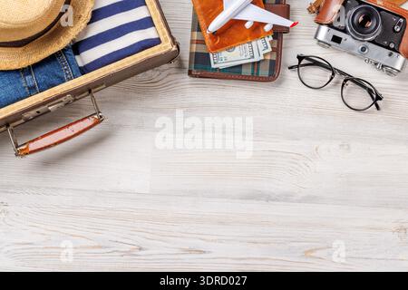 A travel bag with clothes, sun hat, flip flops, and a camera Stock Photo