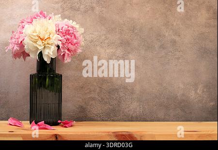 Abstract floral arrangement, empty wooden table and fresh peony flowers in vase, stage for product display and business concept. Stock Photo