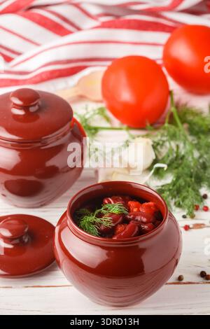 Stewed red beans with tomatoes and garlic in a ceramic pot. Vegetarian dish Stock Photo