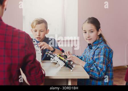 Kids Working Together on Robot Models in a Classroom Setting Stock Photo