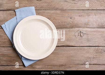 Empty plate and blue napkin on wooden background Stock Photo