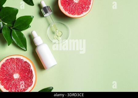 Bottle of grapefruit essential oil and fresh citrus Stock Photo