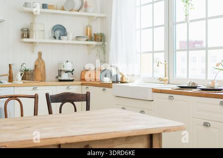 Empty white wooden kitchen interior with dining room. Scandinavian classic minimalistic bright kitchen with white and wooden det Stock Photo