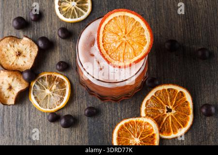 Drink With Dried Orange Slices on Wooden Table With Chocolate Balls Around It Stock Photo