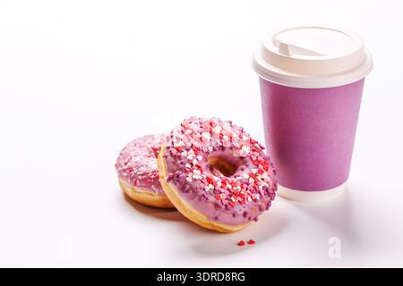 A cheerful display of donuts and a paper coffee cup on a white background Stock Photo