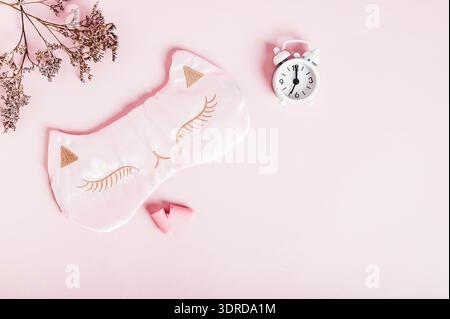 Concept insomnia sleep mask, earplugs and alarm clock on pink background Stock Photo