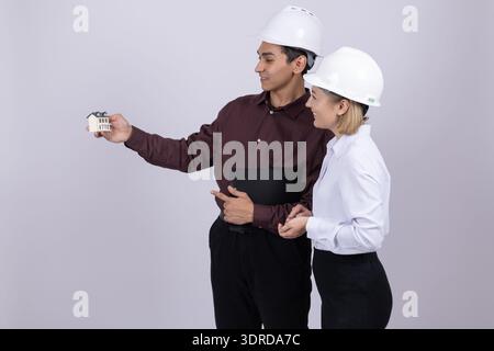 Engineer showing something on smartphone to female colleague Stock Photo