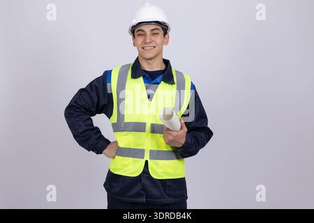 Confident male worker in safety vest with hands on hips Stock Photo