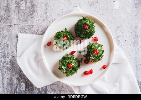 Close up of tuna, egg and dill salad shaped like Christmas trees on crackers on a plate top view Stock Photo