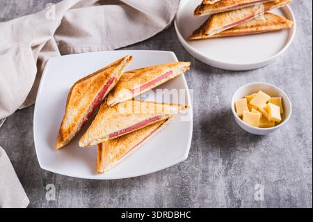 Toasted ham and cheese toasts on a plate on the table Stock Photo