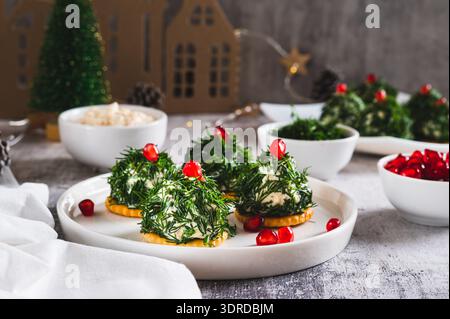 Tuna, egg and dill salad shaped like Christmas trees on crackers on a plate Stock Photo