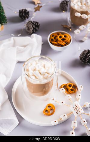 Hot chocolate with marshmallows and pretzels and snowflake on a plate vertical view Stock Photo